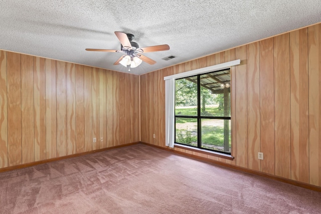 2200 Rawls Rd, Greenbrier, TN 37073 - unfurnished room with carpet floors, wooden walls, ceiling fan, and a textured ceiling