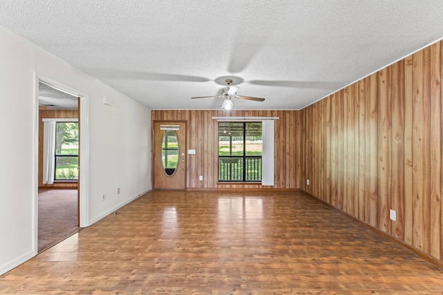 2200 Rawls Rd, Greenbrier, TN 37073 - empty room featuring wood finished floors, plenty of natural light, wood walls, ceiling fan, and a textured ceiling