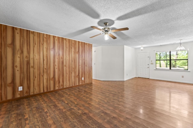 2200 Rawls Rd, Greenbrier, TN 37073 - unfurnished living room featuring ceiling fan, wood finished floors, a textured ceiling, and wooden walls