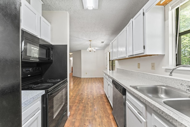 2200 Rawls Rd, Greenbrier, TN 37073 - kitchen with black appliances, wood finished floors, white cabinetry, a textured ceiling, and a chandelier