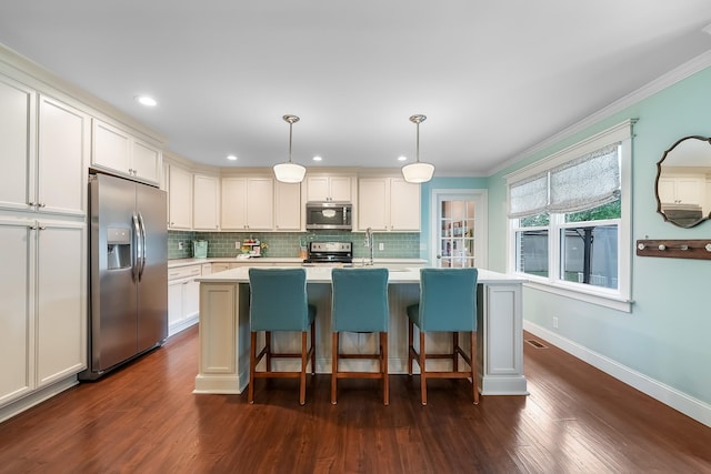 509 Iris Ave, Murfreesboro, TN 37128 - kitchen with appliances with stainless steel finishes, light countertops, tasteful backsplash, ornamental molding, and an island with sink