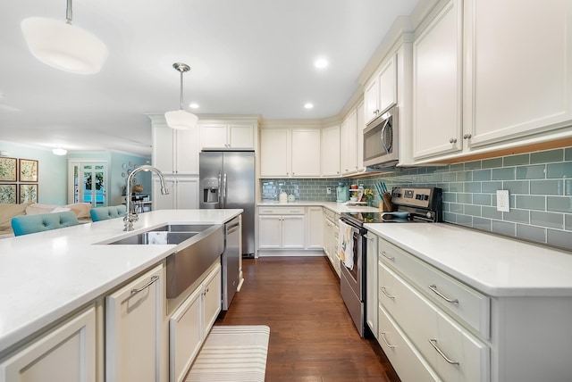 509 Iris Ave, Murfreesboro, TN 37128 - kitchen featuring appliances with stainless steel finishes, tasteful backsplash, light countertops, decorative light fixtures, and dark wood-style flooring