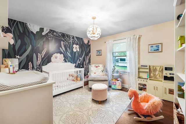 509 Iris Ave, Murfreesboro, TN 37128 - bedroom with wood finished floors, a crib, and a chandelier