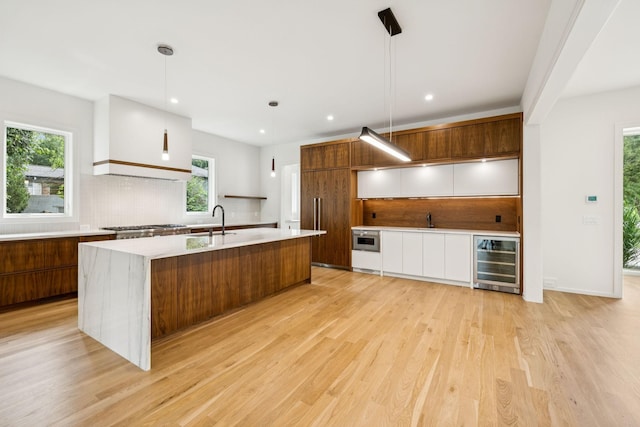 4045 Outer Dr, Nashville, TN 37204 - kitchen with wine cooler, modern cabinets, decorative backsplash, light countertops, and light wood-type flooring