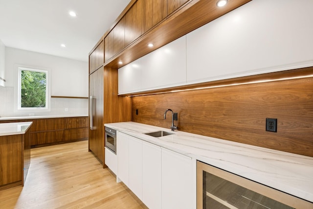 4045 Outer Dr, Nashville, TN 37204 - kitchen with wine cooler, modern cabinets, white cabinetry, light wood-style flooring, and brown cabinets