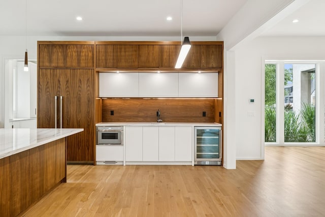 4045 Outer Dr, Nashville, TN 37204 - kitchen featuring beverage cooler, white cabinetry, light wood-style flooring, modern cabinets, and pendant lighting