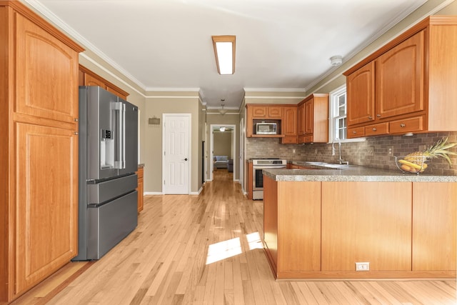 1903 Palmer Dr, Springfield, TN 37172 - kitchen with appliances with stainless steel finishes, a peninsula, light wood-style flooring, decorative backsplash, and ornamental molding