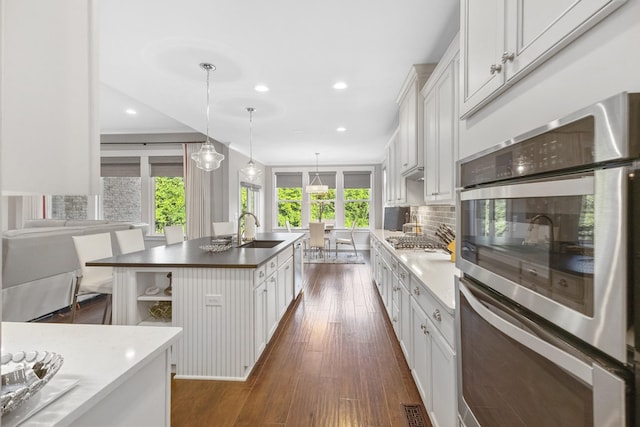 2030 Oliver Dr, Mount Juliet, TN 37122 - kitchen featuring stainless steel appliances, dark wood-type flooring, open shelves, decorative backsplash, and a center island with sink