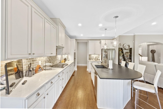2030 Oliver Dr, Mount Juliet, TN 37122 - kitchen featuring appliances with stainless steel finishes, ornamental molding, wood finished floors, arched walkways, and decorative backsplash
