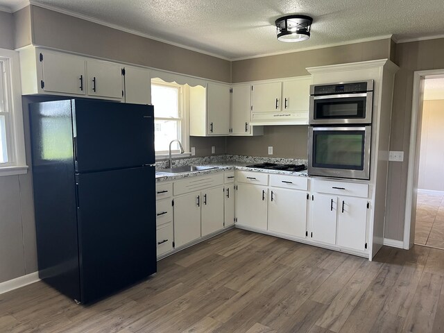 208 Skyline Dr, Red Boiling Springs, TN 37150 - kitchen featuring black appliances, under cabinet range hood, wood finished floors, a textured ceiling, and crown molding
