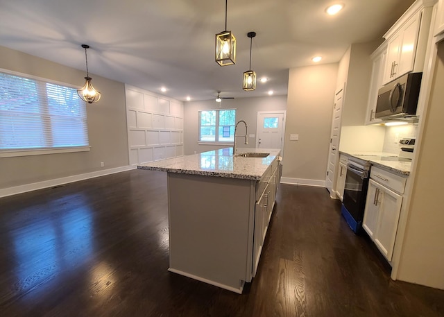 4211 Woods St, Old Hickory, TN 37138 - kitchen featuring appliances with stainless steel finishes, dark wood-type flooring, a center island with sink, recessed lighting, and light stone counters