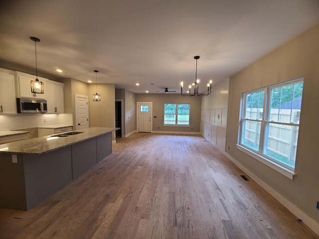 4211 Woods St, Old Hickory, TN 37138 - kitchen featuring stainless steel microwave, a chandelier, wood finished floors, recessed lighting, and white cabinets