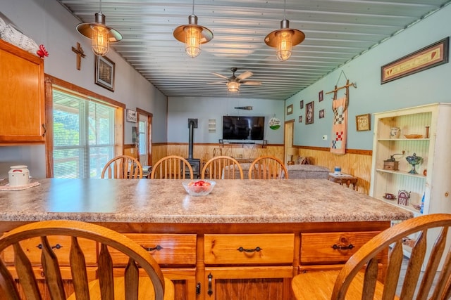 357 Providence Rd, Pulaski, TN 38478 - kitchen with wainscoting, a ceiling fan, wooden walls, open floor plan, and pendant lighting