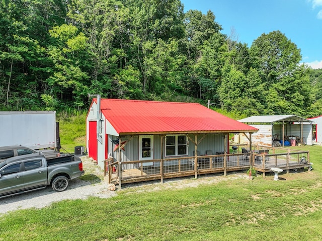 357 Providence Rd, Pulaski, TN 38478 - view of front of home with board and batten siding, a front lawn, a detached carport, a metal roof, and a porch