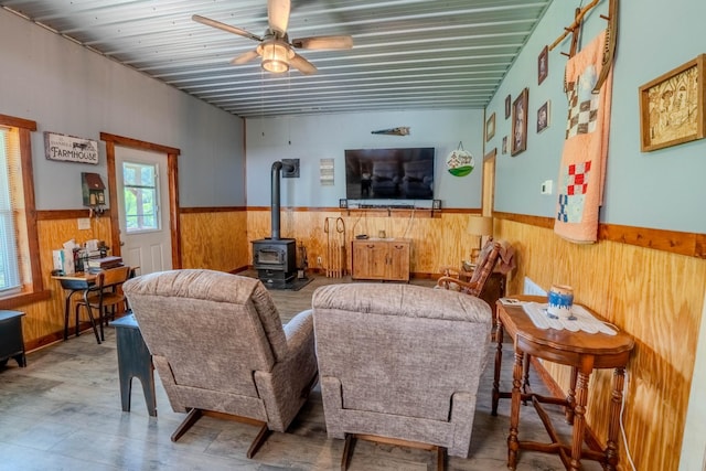 357 Providence Rd, Pulaski, TN 38478 - living room featuring a wood stove, wooden walls, a wainscoted wall, and a ceiling fan
