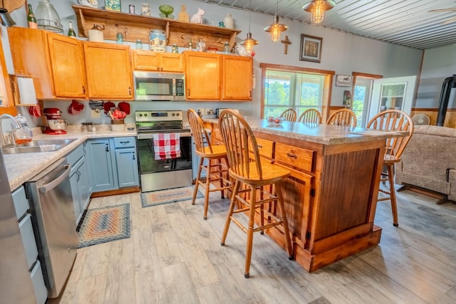 357 Providence Rd, Pulaski, TN 38478 - kitchen featuring stainless steel appliances, light wood-style floors, a breakfast bar area, light countertops, and decorative light fixtures