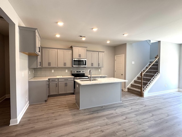 564 Twyla Dr, Lebanon, TN 37087 - kitchen with stainless steel appliances, gray cabinetry, decorative backsplash, light wood-style floors, and recessed lighting
