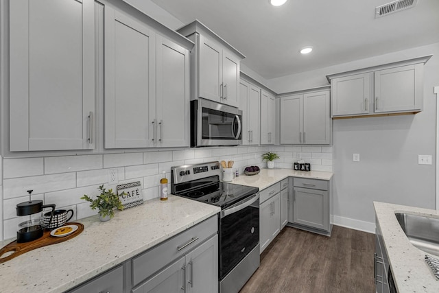 564 Twyla Dr, Lebanon, TN 37087 - kitchen featuring appliances with stainless steel finishes, gray cabinetry, dark wood-style floors, light stone counters, and recessed lighting