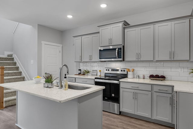 564 Twyla Dr, Lebanon, TN 37087 - kitchen featuring appliances with stainless steel finishes, gray cabinetry, wood finished floors, tasteful backsplash, and recessed lighting