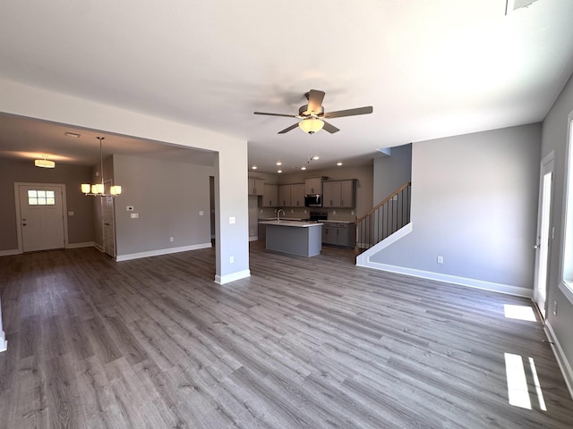 564 Twyla Dr, Lebanon, TN 37087 - unfurnished living room with ceiling fan, wood finished floors, a chandelier, stairs, and recessed lighting