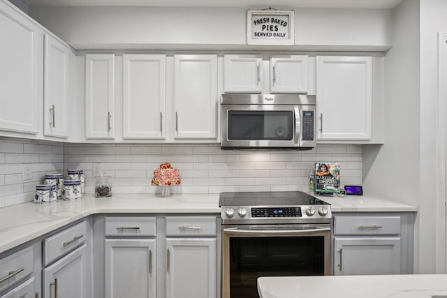 4858 Chelanie Cir, Murfreesboro, TN 37129 - kitchen featuring appliances with stainless steel finishes, tasteful backsplash, white cabinets, and light stone countertops