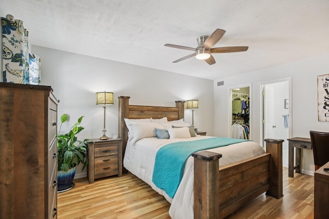 4858 Chelanie Cir, Murfreesboro, TN 37129 - bedroom with light wood-style floors, a spacious closet, a ceiling fan, a textured ceiling, and a closet