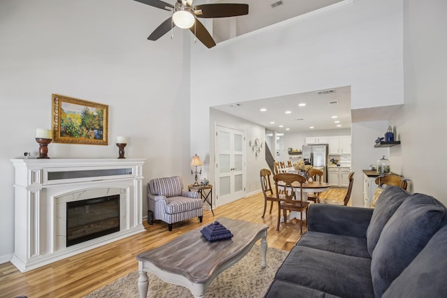 4858 Chelanie Cir, Murfreesboro, TN 37129 - living room with ceiling fan, light wood finished floors, a fireplace, and a towering ceiling