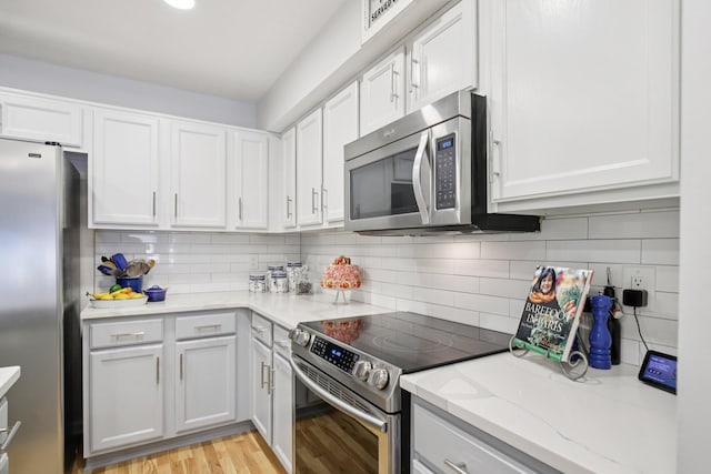 4858 Chelanie Cir, Murfreesboro, TN 37129 - kitchen featuring appliances with stainless steel finishes, light wood finished floors, white cabinetry, and backsplash