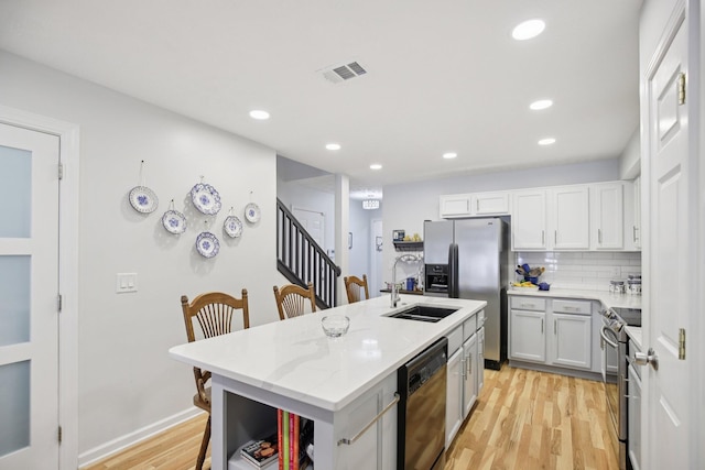 4858 Chelanie Cir, Murfreesboro, TN 37129 - kitchen featuring stainless steel appliances, light wood-type flooring, an island with sink, recessed lighting, and a kitchen bar
