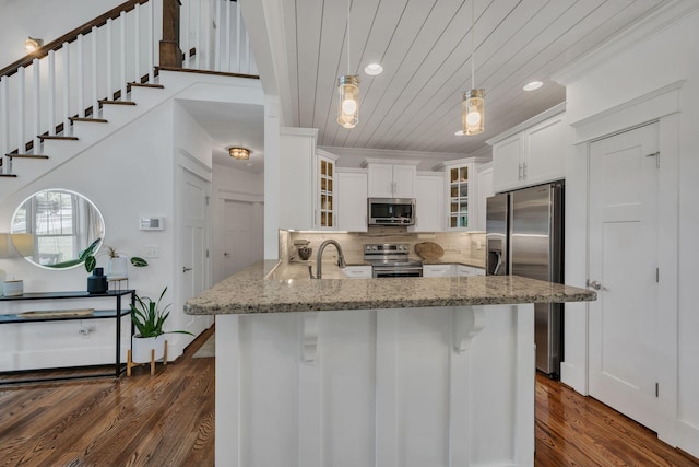 7106 Pepper Tree Cir, Fairview, TN 37062 - kitchen with stainless steel appliances, wooden ceiling, a peninsula, light stone countertops, and dark wood-type flooring
