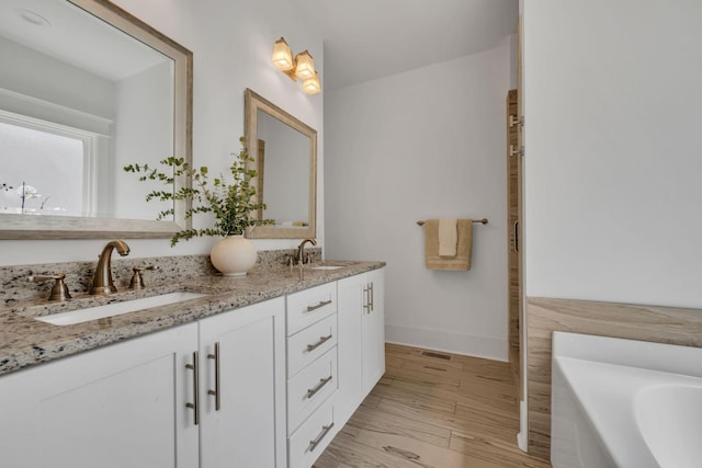 7106 Pepper Tree Cir, Fairview, TN 37062 - bathroom featuring double vanity, a bath, and wood finished floors