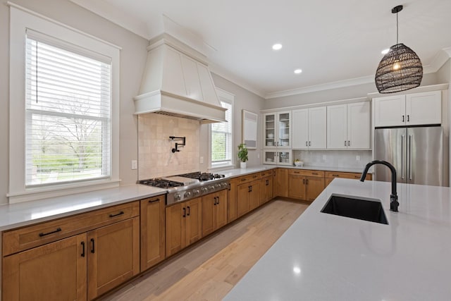 9409 Clovercroft Rd, Franklin, TN 37067 - kitchen with appliances with stainless steel finishes, custom exhaust hood, light wood-style flooring, decorative backsplash, and light countertops