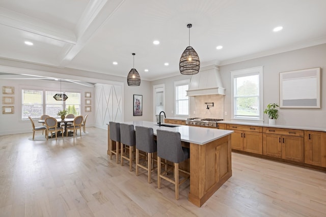 9409 Clovercroft Rd, Franklin, TN 37067 - kitchen with light wood-style floors, recessed lighting, an island with sink, light countertops, and a breakfast bar area