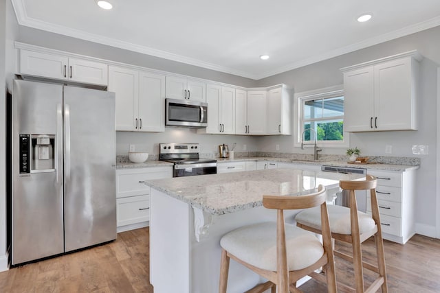 1268 S Tidwell Rd, Bon Aqua, TN 37025 - kitchen featuring appliances with stainless steel finishes, white cabinets, light wood-style floors, a breakfast bar area, and recessed lighting