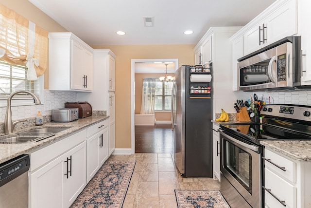 128 Thomas Traylor Ln, Clarksville, TN 37043 - kitchen featuring stainless steel appliances, plenty of natural light, white cabinets, decorative backsplash, and recessed lighting