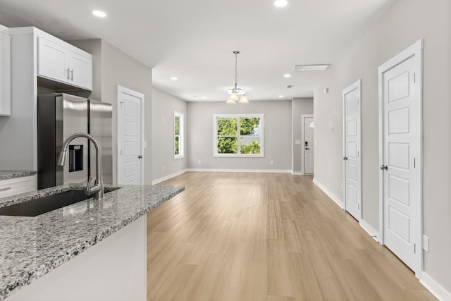 415 9th St, Clarksville, TN 37040 - kitchen featuring stainless steel fridge, light wood-type flooring, white cabinetry, pendant lighting, and recessed lighting