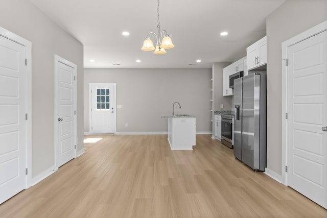 415 9th St, Clarksville, TN 37040 - kitchen featuring stainless steel appliances, a chandelier, white cabinets, light wood-style floors, and light stone counters