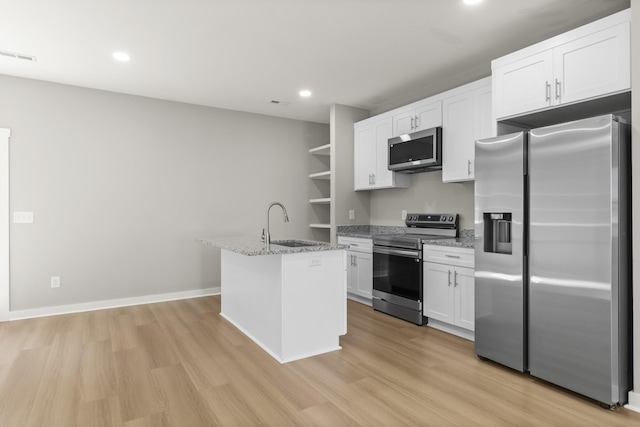 415 9th St, Clarksville, TN 37040 - kitchen featuring appliances with stainless steel finishes, light wood finished floors, open shelves, white cabinetry, and light stone countertops