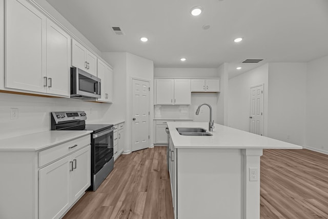 2900 Suzanne Landon Dr Unit E2, Murfreesboro, TN 37130 - kitchen featuring appliances with stainless steel finishes, light wood finished floors, white cabinets, a center island with sink, and recessed lighting