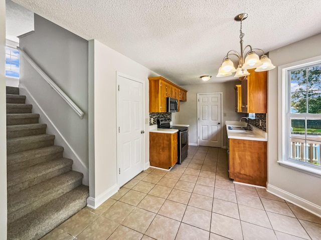 1333 Meredith Way, Clarksville, TN 37042 - kitchen with stainless steel appliances, light countertops, light tile patterned floors, brown cabinetry, and tasteful backsplash