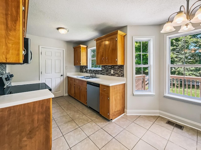 1333 Meredith Way, Clarksville, TN 37042 - kitchen with appliances with stainless steel finishes, light tile patterned floors, light countertops, brown cabinetry, and a textured ceiling