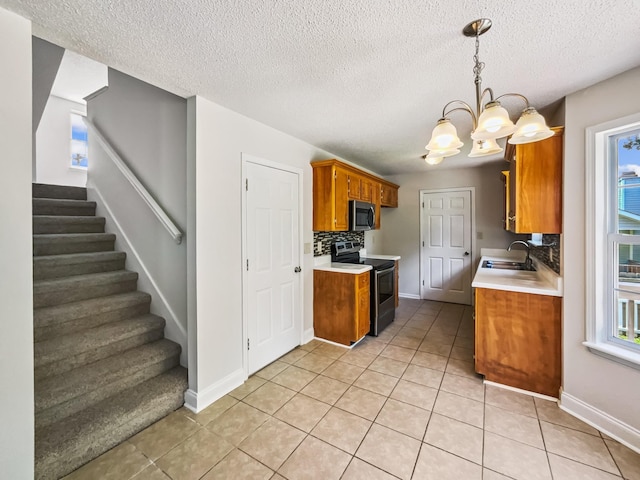 1333 Meredith Way, Clarksville, TN 37042 - kitchen with appliances with stainless steel finishes, brown cabinets, light countertops, light tile patterned floors, and a textured ceiling