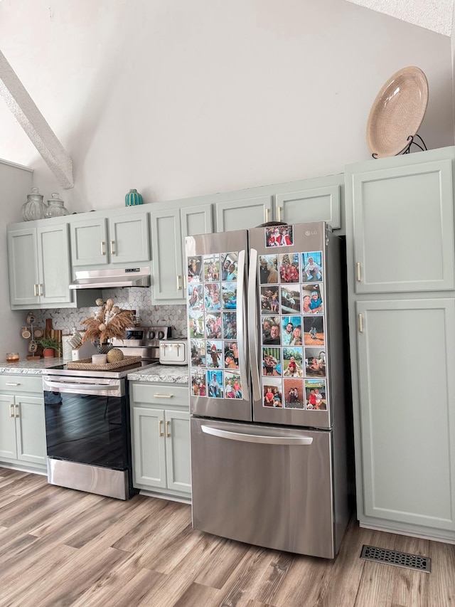 108 Easy St, Pulaski, TN 38478 - kitchen with appliances with stainless steel finishes, under cabinet range hood, tasteful backsplash, light wood-type flooring, and vaulted ceiling