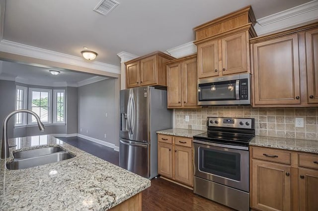 991 Westhaven Blvd Unit 32, Franklin, TN 37064 - kitchen featuring appliances with stainless steel finishes, ornamental molding, dark wood-style flooring, and brown cabinets