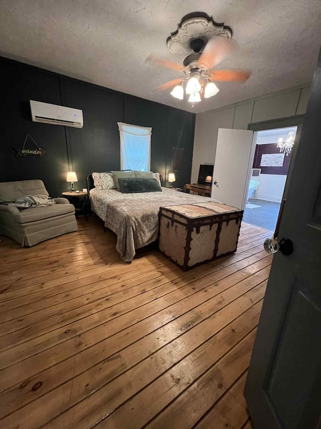 2016 Tennessee St, Westpoint, TN 38486 - bedroom featuring hardwood / wood-style floors, a wall unit AC, a textured ceiling, and a ceiling fan