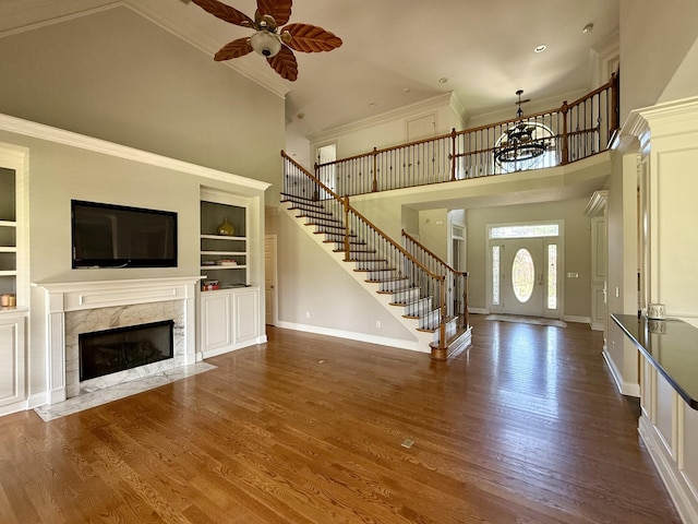 1413 Station Four Ln, Old Hickory, TN 37138 - unfurnished living room with a towering ceiling, stairway, built in features, a ceiling fan, and a fireplace