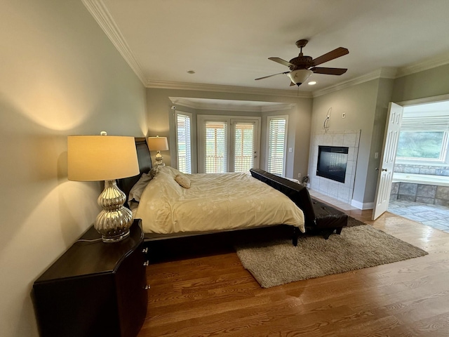 1413 Station Four Ln, Old Hickory, TN 37138 - bedroom featuring multiple windows, wood finished floors, crown molding, a tiled fireplace, and ceiling fan