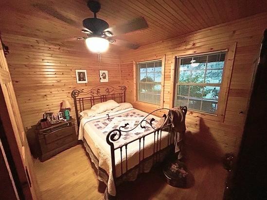 2933 Vanzant Bend Rd, Belvidere, TN 37306 - bedroom featuring wooden walls, light wood-style flooring, wood ceiling, and ceiling fan