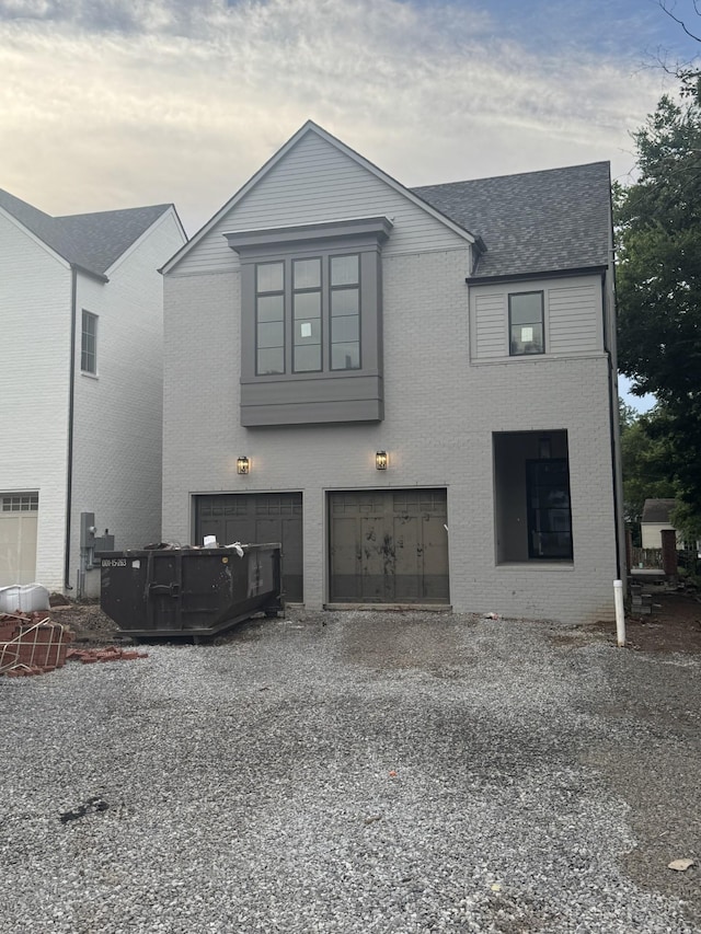 4153 Outer Dr, Nashville, TN 37204 - view of front of property featuring gravel driveway, brick siding, a garage, and a shingled roof