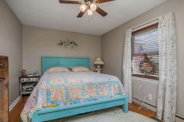 6191 Baxter Rd, Baxter, TN 38544 - bedroom featuring baseboard heating, wood finished floors, and a ceiling fan